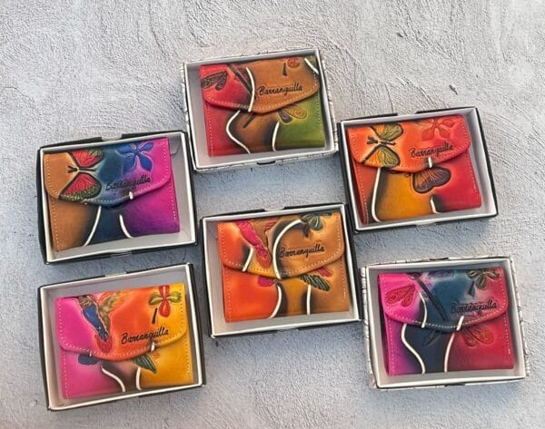 Billeteras artesanales de cuero con mariposas, hechas en Barranquilla, disponibles en colores surtidos, diseño exclusivo con caja de presentación.